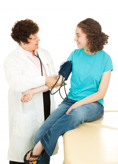 Teenage girl visiting her physician for a checkup.  The doctor is taking her blood pressure.- Image